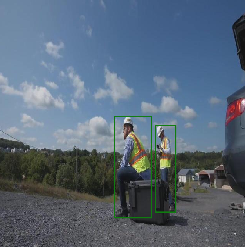 Outdoor gravel site — two workers in hi-vis yellow vests (green boxes)